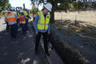 Pacific Gas and Electric CEO Patti Poppe looks down while being interviewed during a tour of PG&E workers burying power lines in Vacaville, Calif., Wednesday, Oct. 11, 2023. PG&E wants to bury many of its power lines in areas threatened by wildfires. (AP Photo/Jeff Chiu)