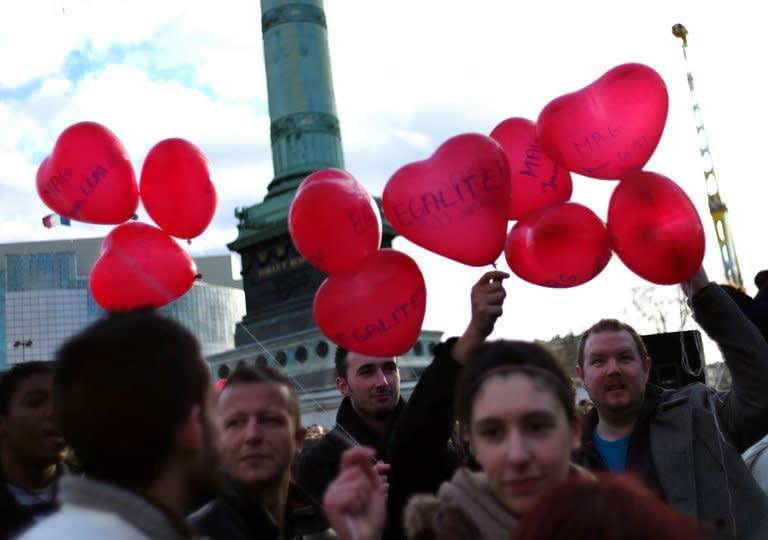 People walk in the Place de la Bastille in Paris on December 16, 2012 during a demonstration for the legalisation of gay marriage and LGBT (lesbian, gay, bisexual, and transgender) parenting. Passions and tensions are rising in France ahead of an expected giant weekend rally against the government's plan to legalise same-sex marriage and adoption that has angered Catholic and Muslim groups