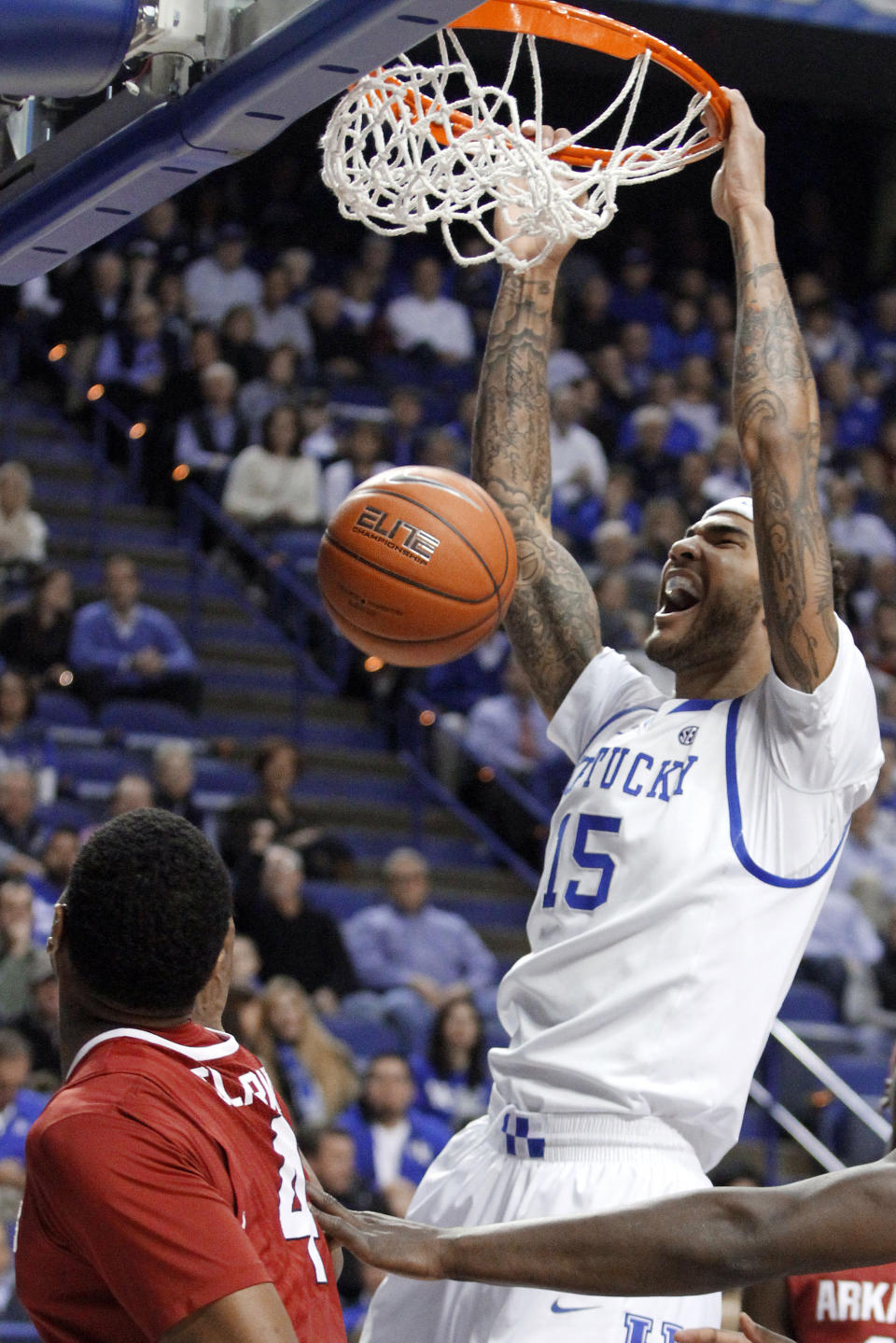 Kentucky's Willie Cauley-Stein (15) dunks next to Arkansas' Coty Clarke (4) during the first half of an NCAA college basketball game Thursday, Feb. 27, 2014, in Lexington, Ky. (AP Photo/James Crisp)