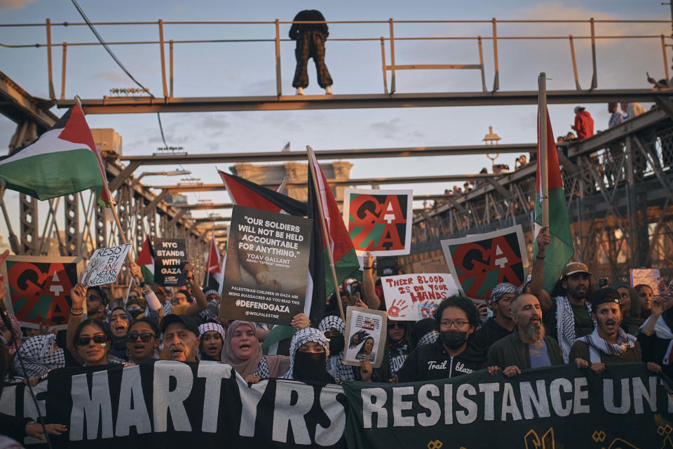 Palestinian supporters shout slogans as they cross the Brooklyn Bridge during a demonstration demanding a cease-fire on Saturday, Oct. 28, 2023, in New York. (AP Photo/Andres Kudacki)