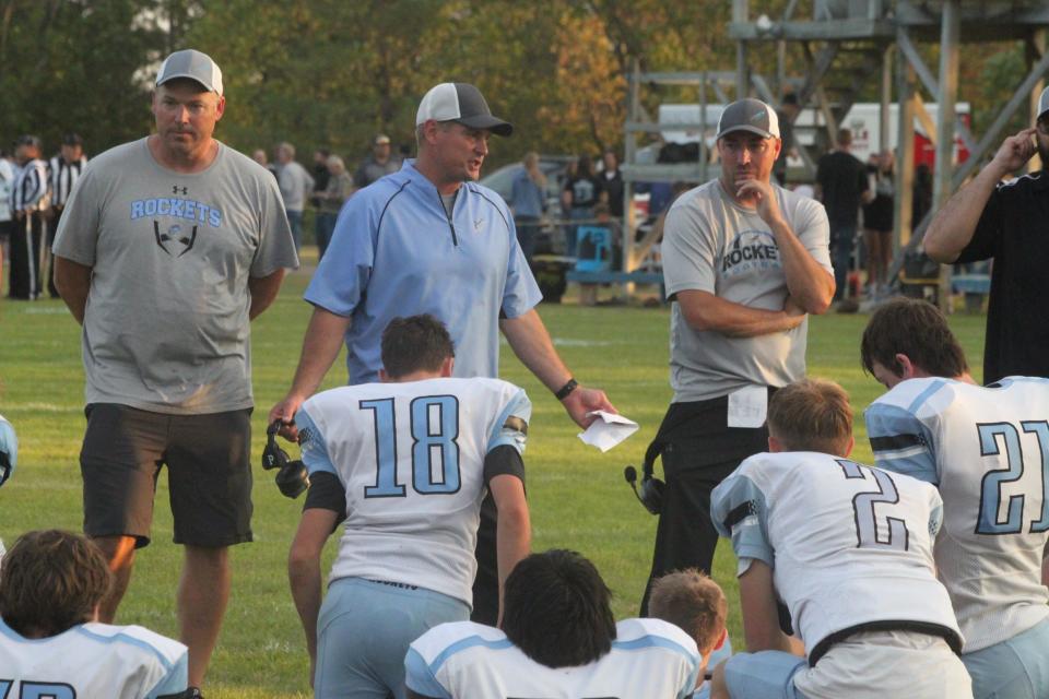 New Rockford-Sheyenne head coach Elliott Belquist (center) talks with his team during halftime.