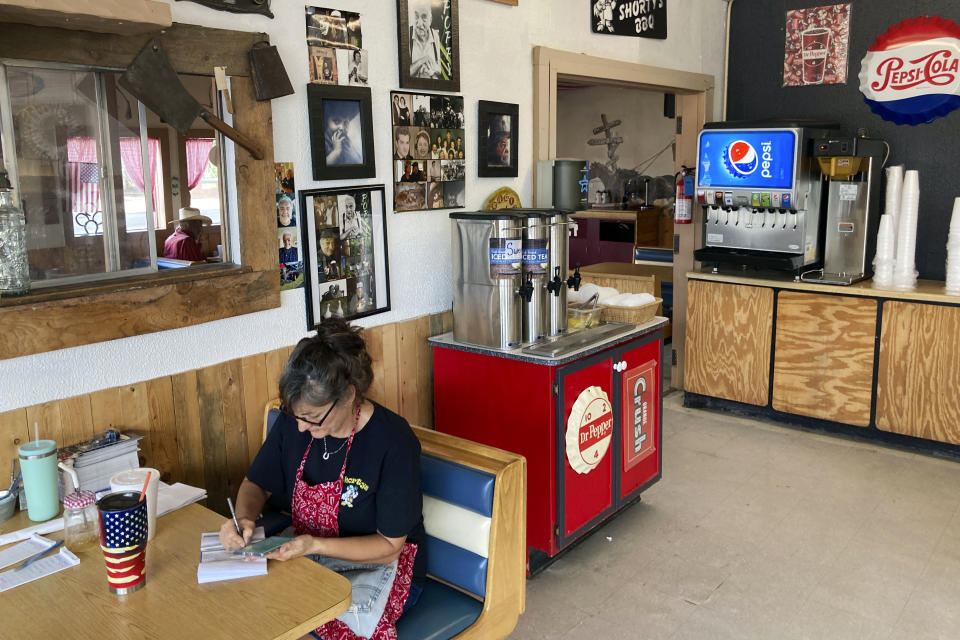 Shorty's BBQ stand co-founder Leanne Tapia pays bills during an afternoon lull on Sept. 14 , 2022, in Moriarty, N.M. She's running for Torrance County commissioner as an independent in the November general election. (AP Photo/Morgan Lee)