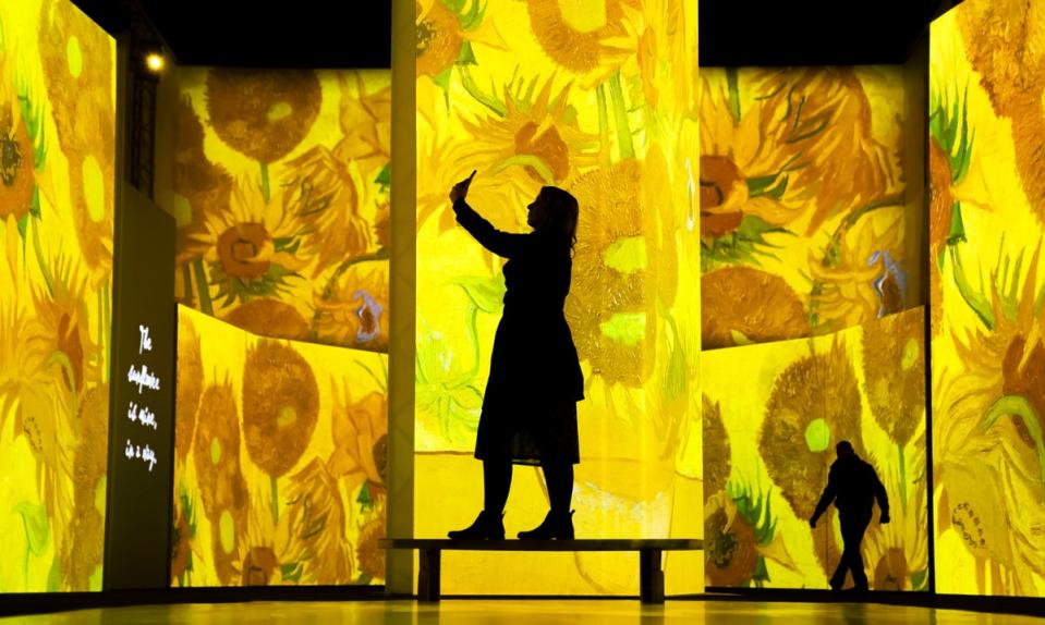 A woman takes a photo at Van Gogh Alive, an immersive, multi-sensory art experience (Danny Lawson / PA Wire)