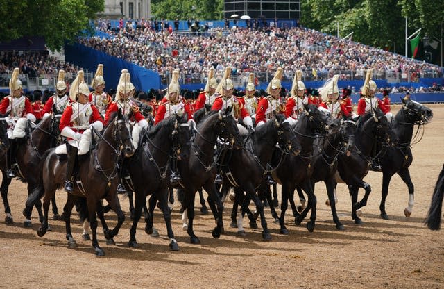 Members of the Household Division trot in unison on horses during the Trooping the Colour ceremony