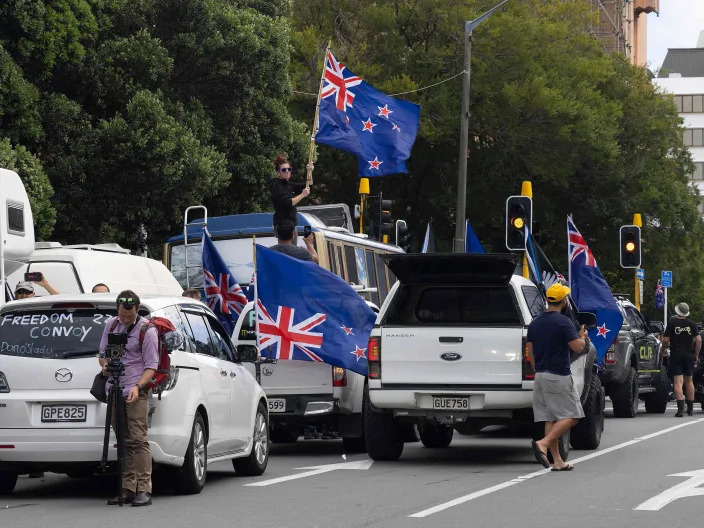 Protesters wave flags from vehicles parked outside the parliament building in Wellington (AFP via Getty Images)