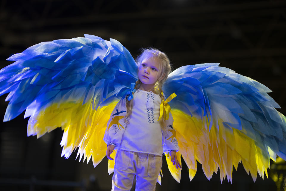 Four-year-old Stefania Lavrenko wears angel wings in the colours of the Ukraine flag during a gathering of Ukrainian refugees at a convention center in Utrecht, Netherlands, Friday, Feb. 24, 2023, to mark the anniversary of the Russian invasion of the Ukraine one year ago. (AP Photo/Peter Dejong)