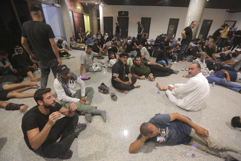 FILE Iraqi protesters rest in the Parliament building in Baghdad, Iraq, Saturday, July 30, 2022. Iraq’s political crisis shows no signs of abating weeks after followers of an influential cleric stormed parliament. That’s despite rising public anger over a debilitating gridlock that has further weakened the country’s caretaker government and its ability to provide basic services. Iraq’s two rival Shiite political camps remain locked in a zero-sum competition, and the lone voice potentially able to end the rift — the revered Grand Ayatollah Ali al-Sistani — has been conspicuously silent. (AP Photo/Anmar Khalil, File)