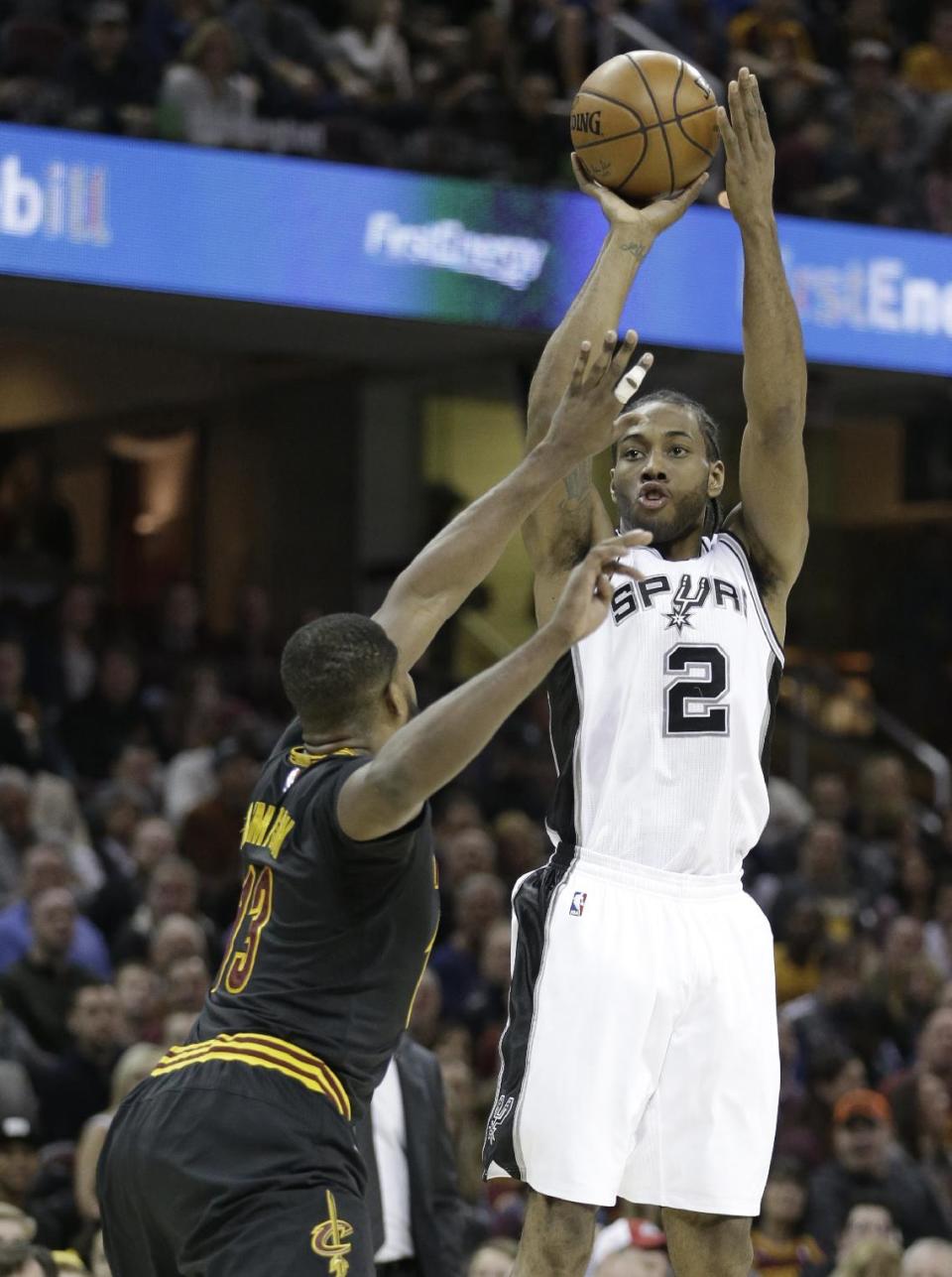 San Antonio Spurs' Kawhi Leonard (2) shoots over Cleveland Cavaliers' Tristan Thompson (13) in the first half of an NBA basketball game, Saturday, Jan. 21, 2017, in Cleveland. The Spurs won 118-115 in overtime. (AP Photo/Tony Dejak)