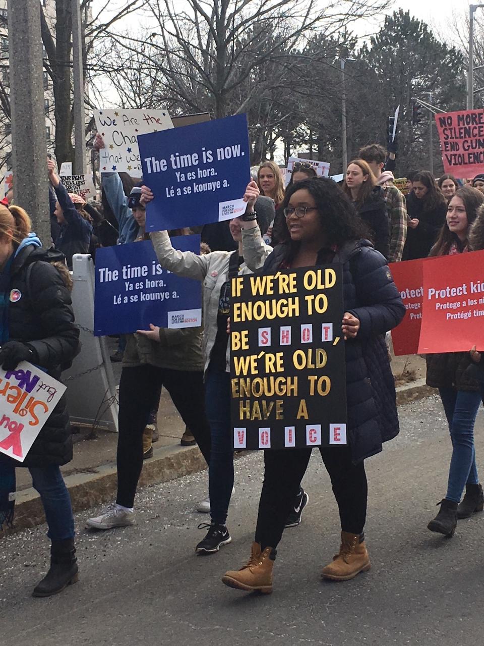 <p>Young people take to the streets with signs in Boston. (Photo: Dave Cronin for Yahoo Lifestyle) </p>