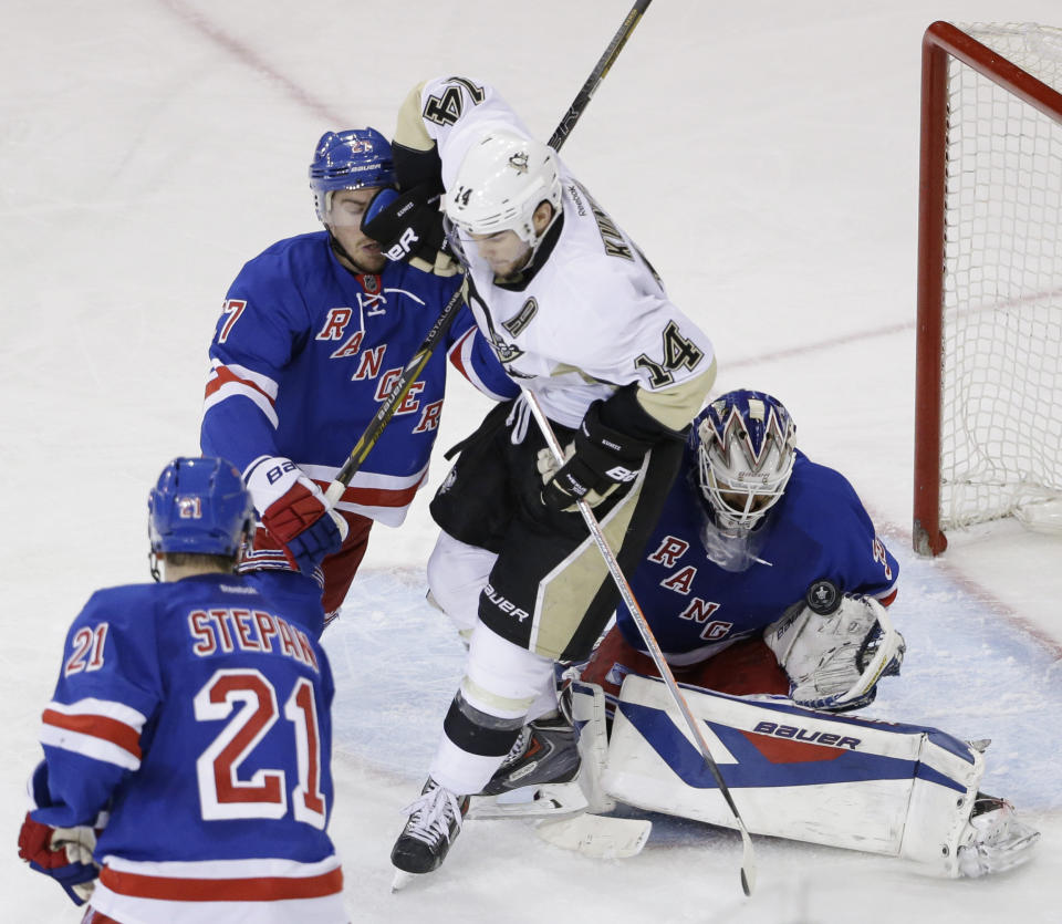 New York Rangers goalie Henrik Lundqvist (30) of Sweden, right, blocks a shot while New York Rangers defenseman Ryan McDonagh (27), second from left, and Pittsburgh Penguins left wing Chris Kunitz (14) collide during the second period of Game 6 of a second-round NHL playoff hockey series, Sunday, May 11, 2014, in New York. (AP Photo/Seth Wenig)