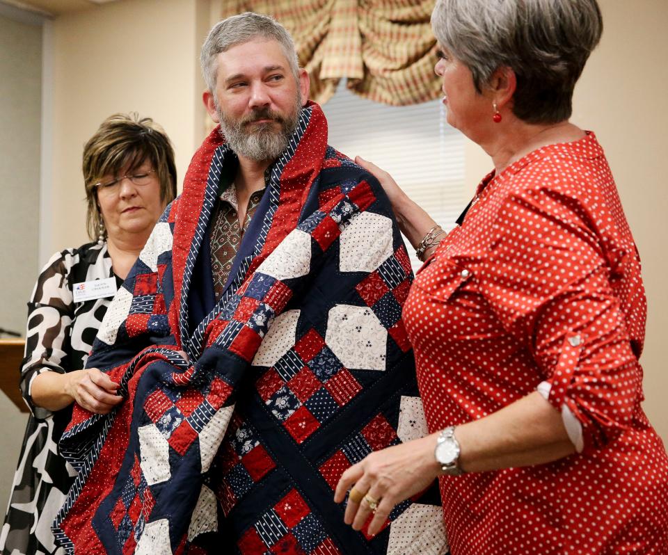 The Daughters of the American Revolution honored three veterans Friday, Nov. 10, 2023, at Northport Baptist Church. A quilt from the Quilts of Valor organization, is draped around the shoulders of Alex Drueke by DAR members Dawn Crocker and Kim Armstrong.