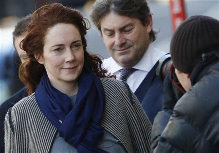 Former News International chief executive Rebekah Brooks and her husband Charlie Brooks are photographed by media as they arrive at the Old Bailey courthouse in London February 21, 2014. REUTERS/Luke MacGregor