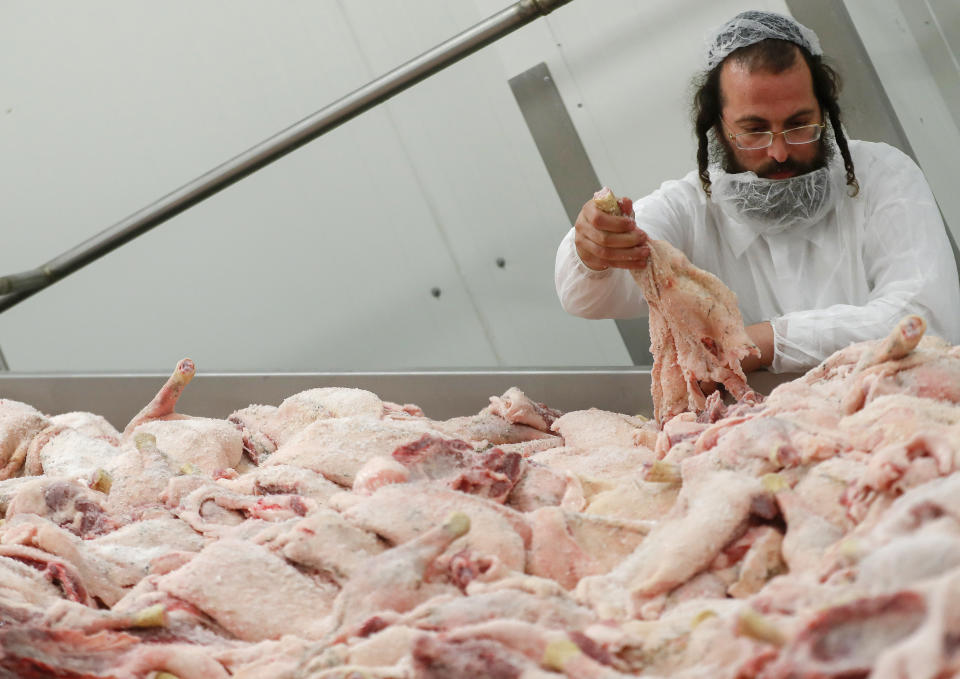 An Orthodox rabbi is checking the quality of poultry meat in a Kosher slaughterhouse in Csengele, Hungary on Jan. 15, 2021. Hungarian Jewish community, exporter of Kosher meat, fear that the European Court of Justice verdict on upholding a Belgian law that banned ritual slaughter could have an affect on other EU member states' regulation on Kosher slaughter. Animal rights groups that pushed for the Flanders law argue that ritual slaughter without stunning amounts to animal cruelty. (AP Photo/Laszlo Balogh)
