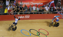 Britain's Jason Kenny (red helmet) celebrates defeating France's Gregory Bauge during the track cycling men's sprint gold finals at the Velodrome during the London 2012 Olympic Games August 6, 2012. Kenny won 2 runs to win the gold medal. REUTERS/Paul Hanna (BRITAIN - Tags: OLYMPICS SPORT CYCLING) 