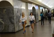 Two women make their way to a train at a Russian Metro station in Moscow August 11, 2013. To step onto the Moscow metro is to step back in time and immerse yourself in a museum rich in architecture and history. Opened in 1935, it is an extravagant gallery of Communist design, featuring Soviet artworks, statues, chandeliers, stained glass and ceiling mosaics. Built under Stalin, the metro now transports 7 to 9 million people a day and costs 30 Rubles, around $1, for a single ride. Picture taken August 11, 2013. REUTERS/Dylan Martinez (RUSSIA - Tags: TRANSPORT SOCIETY) ATTENTION EDITORS: PICTURE 10 OF 24 FOR PACKAGE 'RIDING THE MOSCOW METRO' SEARCH 'MOSCOW CHANDELIERS' FOR ALL IMAGES