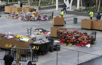 Workers remove thousands of items left in honor of Kobe Bryant, including hundreds of basketballs, from X-Box Plaza across Chick Hearn Court from Staples Center, home of the Los Angeles Lakers, early Monday, Feb. 3, 2020, in Los Angeles. Mourners left the items after the death of the former Lakers legend, his daughter and seven others, in a helicopter crash one week ago. (AP Photo/Reed Saxon)