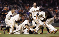 San Francisco Giants' Hector Sanchez, bottom center, is mobbed by teammates after driving in the game-winning run during the 12th inning of a baseball game against the Los Angeles Dodgers on Wednesday, April 16, 2014, in San Francisco. San Francisco won 3-2. (AP Photo/Marcio Jose Sanchez)