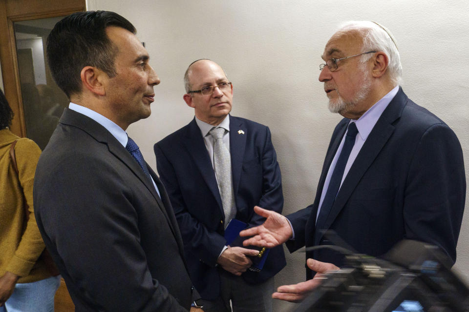 United States Attorney Martin Estrada, left, listens to Rabbi Abraham Cooper, Associate Dean and Director of Global Social Action for the Simon Wiesenthal Center, right, and Hillel Newman, Consul General, Senior Representative of the State of Israel to the Pacific Southwest, middle, after a news conference at the U.S. Attorney's Office Central District of California offices in Los Angeles Friday, Feb. 17, 2023. A person was taken into custody Thursday in connection with the shootings of two Jewish men outside synagogues in Los Angeles this week that investigators believe were hate crimes, police said. (AP Photo/Damian Dovarganes)