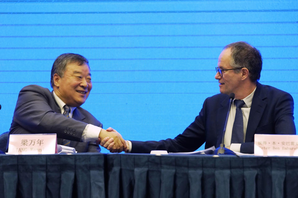 Peter Ben Embarek, of the World Health Organization team, right, shakes hands with his Chinese counterpart Liang Wannian after a WHO-China Joint Study Press Conference held at the end of the WHO mission in Wuhan, China, Tuesday, Feb. 9, 2021. (AP Photo/Ng Han Guan)