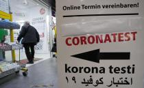 A man walks into a pharmacy, that offers corona tests in Gelsenkirchen, Germany, Friday, Nov. 12, 2021. Germany plans to bring back free Covid-19 rapid tests. (AP Photo/Martin Meissner)