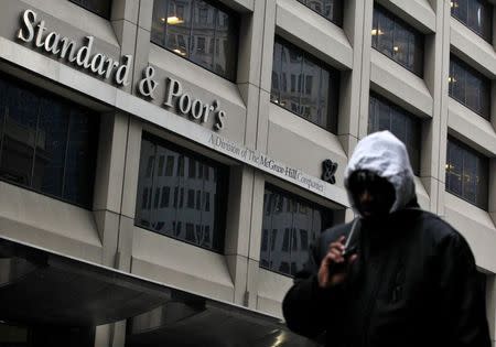 A man walks past the Standard & Poor's building in New York's financial district February 5, 2013. REUTERS/Brendan McDermid