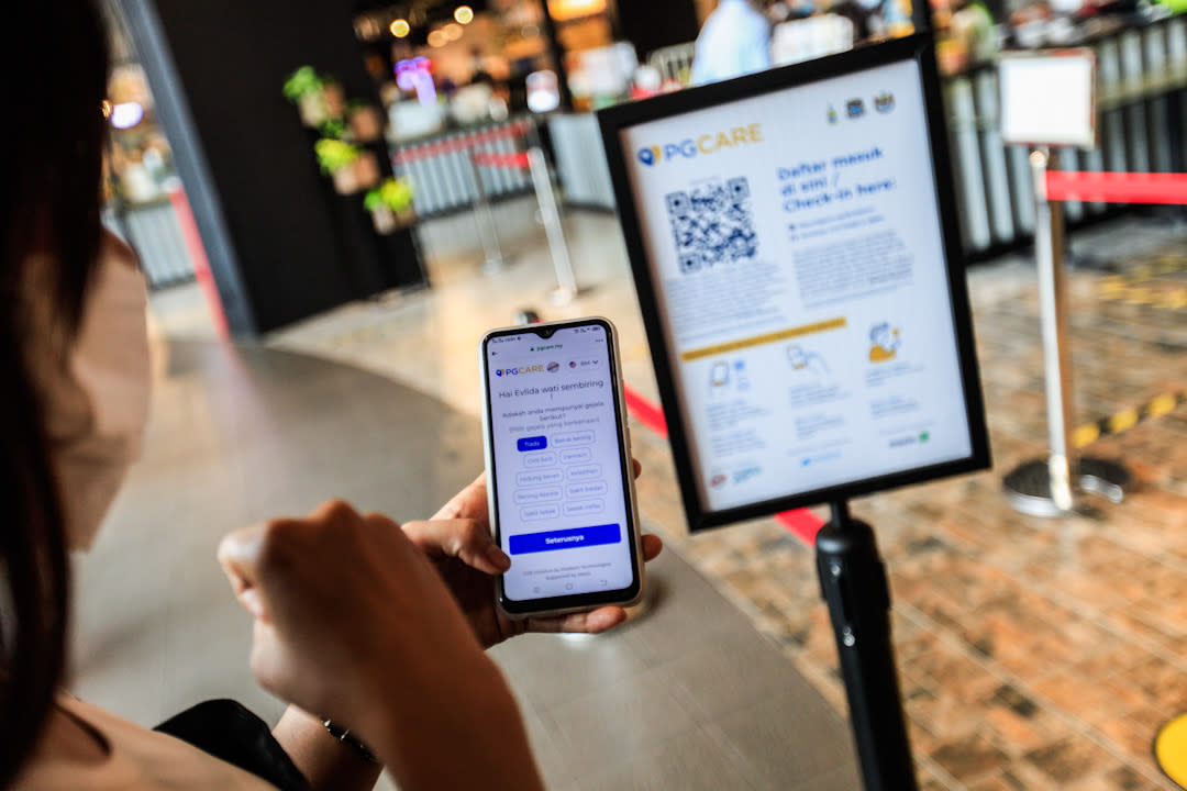 Members of the public are pictured using the PGCare app at the Queensbay Mall in Penang May 18, 2020.  — Picture by Sayuti Zainudin