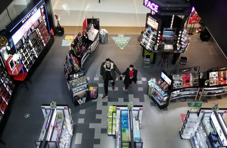 A man and a boy walk at a shopping center in Beijing, China December 14, 2018. REUTERS/Jason Lee