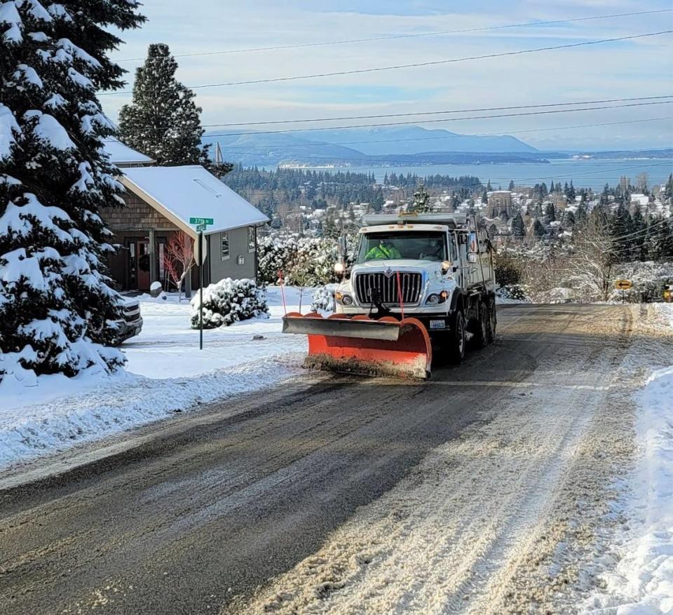 City of Bellingham crews plow snow on Mill Avenue in Bellingham, Wash., after the city got a foot of snow starting Saturday, Dec. 25, 2021.