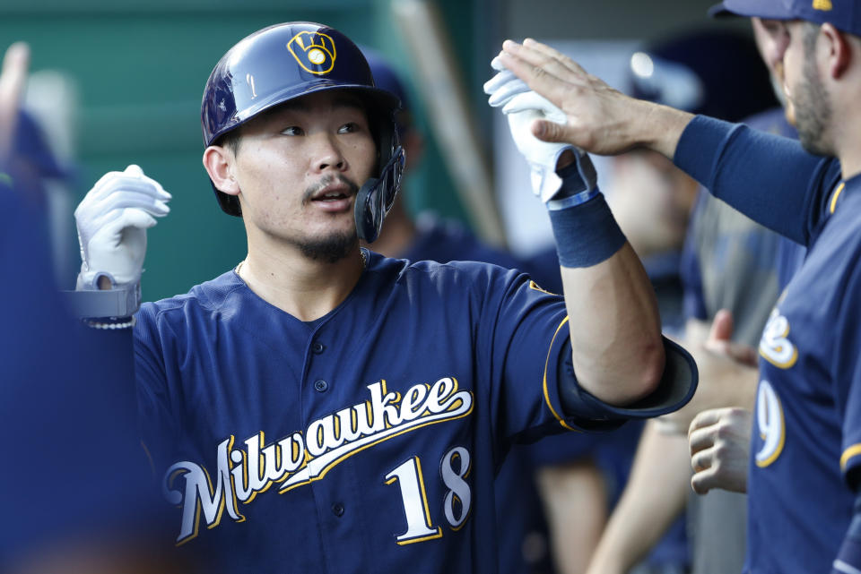 Milwaukee Brewers' Keston Hiura (18) is congratulated in the dugout following a solo home run off Cincinnati Reds starting pitcher Tyler Mahle during the fifth inning of a baseball game, Monday, July 1, 2019, in Cincinnati. (AP Photo/Gary Landers)