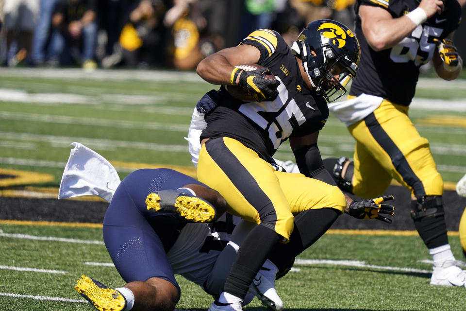 Iowa running back Gavin Williams (25) is tackled by Michigan linebacker Taylor Upshaw (91) after catching a pass during the first half of an NCAA college football game, Saturday, Oct. 1, 2022, in Iowa City, Iowa. (AP Photo/Charlie Neibergall)