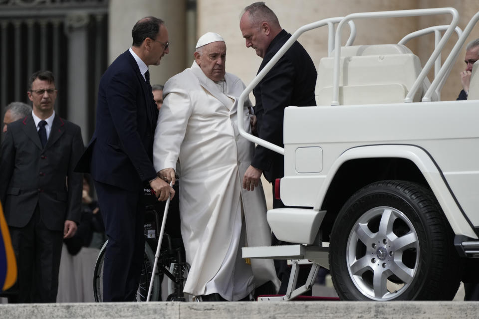 Pope Francis helped to get on his car at the end of weekly general audience in St. Peter's Square, at the Vatican, Wednesday, March 29, 2023. Pope Francis went to a Rome hospital on Wednesday for some previously scheduled tests, slipping out of the Vatican after his general audience and before the busy start of Holy Week this Sunday. (AP Photo/Alessandra Tarantino)