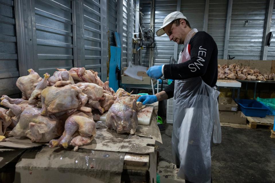 KHARKIV, UKRAINE - SEPTEMBER 26: Workers from Myrne Nebo (Peaceful Sky) a Ukranian humanitarian organization chop frozen chicken that will be cooked and later delivered to liberated villages on September 26 2022 in Kharkiv, Ukraine. The organization collaborates with World Central Kitchen from Washington DC providing the needy with food. In recent weeks, Ukrainian forces have reclaimed villages east and south of Kharkiv, as Russian forces have withdrawn from areas they've occupied since early in the war. (Photo by Paula Bronstein/Getty Images)