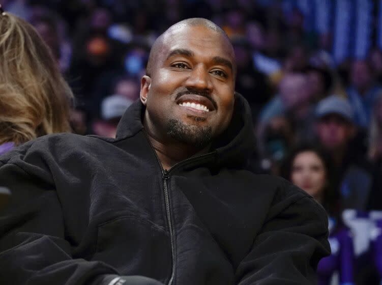 A man smiles while watching a basketball game