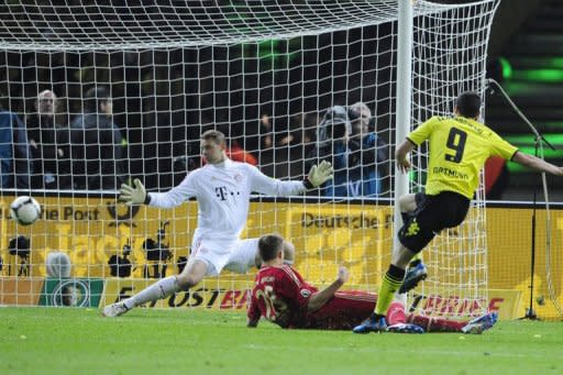 Bayern Munich's goalkeeper Manuel Neuer (L) misses a goal scored by Dortmund's striker Robert Lewandowski (R) during the German cup final at the Olympiastadion in Berlin. Dortmund won 5-2