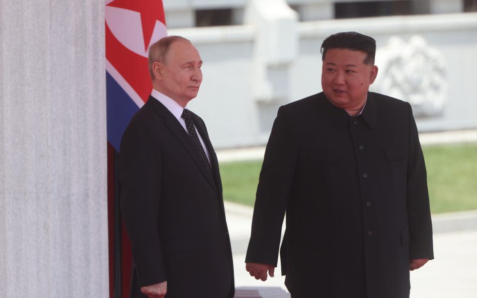 Russian President Vladimir Putin (L) and North Korean Supreme Leader Kim Jong Un (R) attend a welcoming ceremony