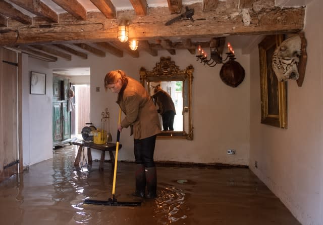 Local resident Roz attempts a clean-up operation in Cossington, as floodwaters cover the ground floor in her home 