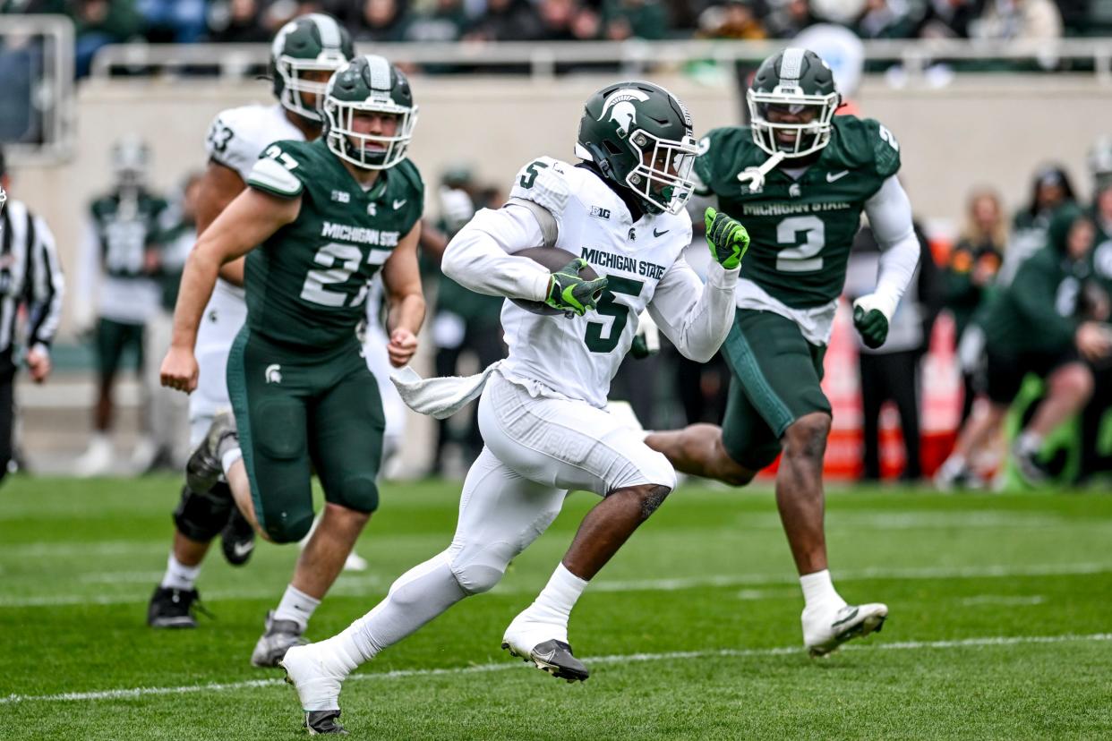 Michigan State football running back Nathan Carter (5) runs for a touchdown as linebacker Cal Haladay (27) and defensive end Khris Bogle (2) give chase during the Spring Showcase on Saturday, April 20, 2024, at Spartan Stadium in East Lansing.