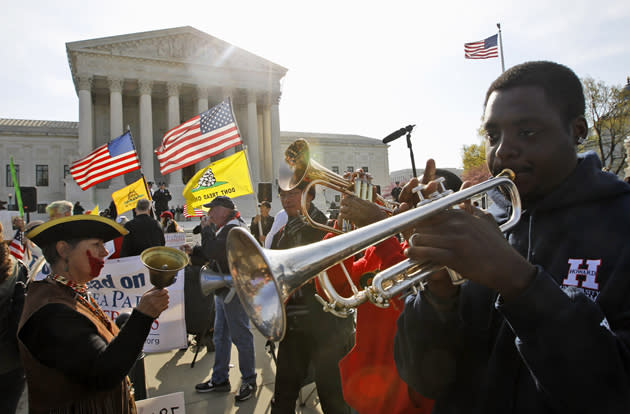 Jonathan Neal, a senior at Howard University, plays his trumpet in support of health care reform in front of the Supreme Court.