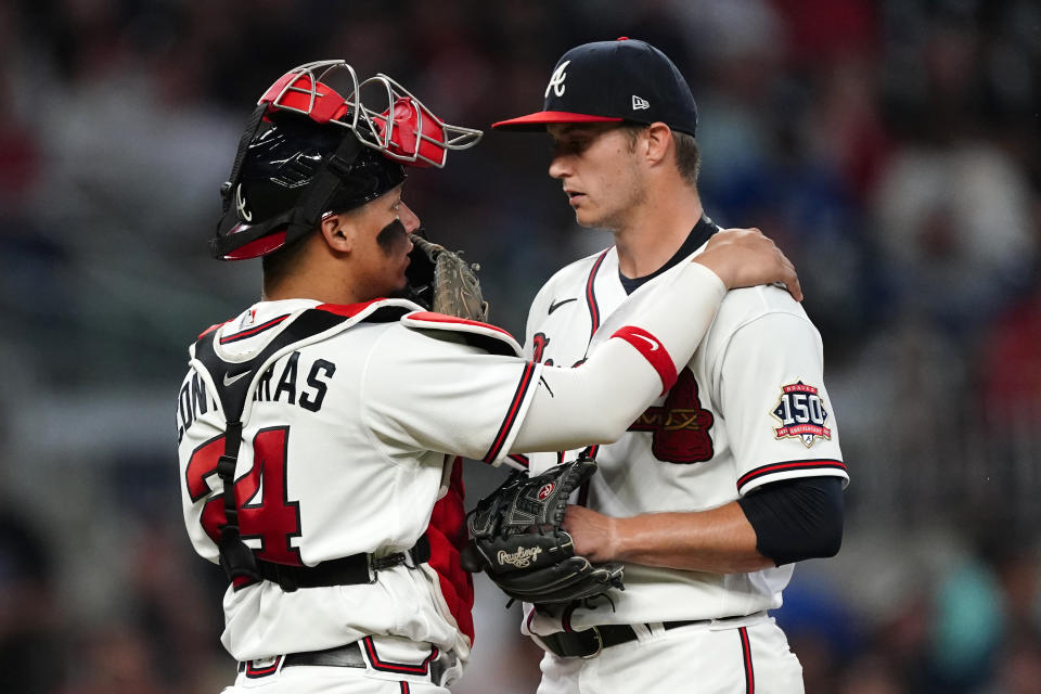 Atlanta Braves catcher William Contreras (24) talks with pitcher Tucker Davidson during the fifth inning of the team's baseball game against the New York Mets on Tuesday, May 18, 2021, in Atlanta. (AP Photo/John Bazemore)