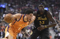 Phoenix Suns guard Devin Booker (1) moves around Toronto Raptors forward Pascal Siakam (43) during the first half of an NBA basketball game Friday, Feb. 21, 2020, in Toronto. (Frank Gunn/The Canadian Press via AP)