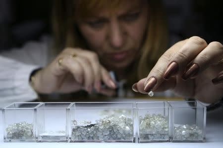 An employee sorts rough diamonds at a sorting centre, owned by Alrosa company, in Moscow, October 18, 2013. REUTERS/Sergei Karpukhin/Files