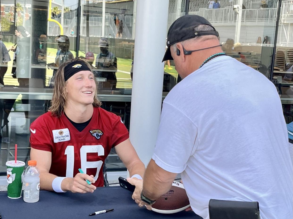 Jaguars quarterback Trevor Lawrence signs autographs for fans after the team's first training camp session on Wednesday at the Miller Electric Center.