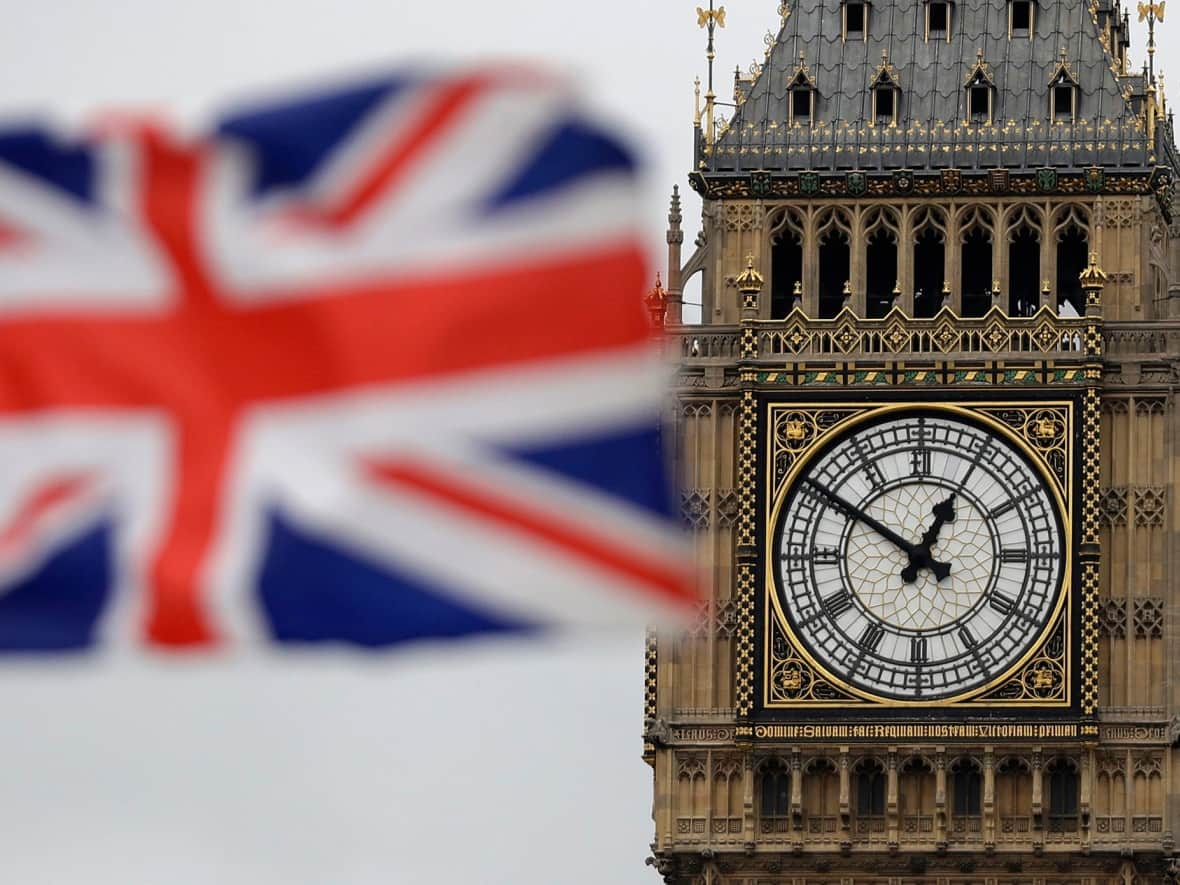 A British flag flies in the wind near to Big Ben's clock tower in front of the Houses of Parliament in central London. The U.K. government is demanding 'proof-of-life' from thousands of its pensioners living in Canada. (Matt Dunham/Associated Press - image credit)