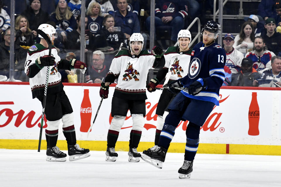 Arizona Coyotes left wing Matias Maccelli (63) celebrates his goal as Winnipeg Jets center Gabriel Vilardi (13) skates back to the bench during the second period of an NHL hockey game in Winnipeg, Manitoba on Sunday, Feb. 25, 2024. (Fred Greenslade/The Canadian Press via AP)