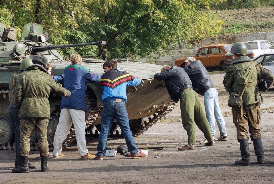 FILE - Five men suspected of looting are held by a Russian Army soldier near the parliament building in Moscow, on Oct. 5, 1993. The October 1993 violent showdown between the Kremlin and supporters of the rebellious parliament marked a watershed in Russia's post-Soviet history. (AP Photo/Diether Endlicher, File)