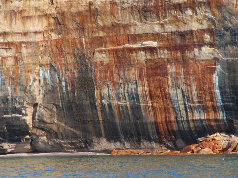 Von herausgespülten Mineralien bunt gefärbt - Eisen zum Beispiel sorgt für die Rottöne an den Pictured Rocks. Foto: Christian Röwekamp