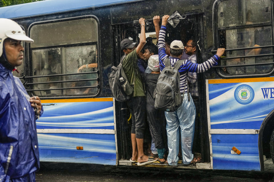 Commuters travel in a crowded bus in Kolkata, India, as rain continues after cyclone Remal made a landfall near Bangladesh-India border, Monday, May 27, 2024. (AP Photo/Bikas Das)