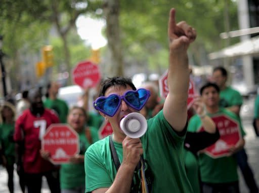 A man takes part in a protest in front of a bank in Barcelona on June 6. Spain's distressed banks need about 40 billion euros ($50 billion) in new capital, the IMF warned, ramping up the pressure for a huge EU bailout amid fears of widespread contagion