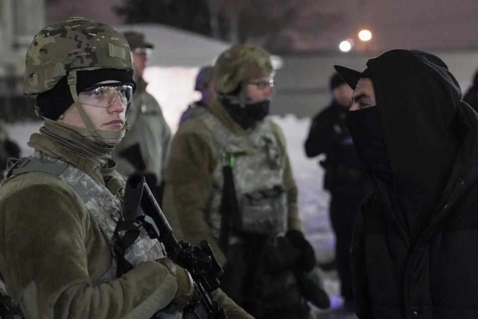 A protester confronts a National Guard member outside a museum, Tuesday, Jan. 5, 2021, in Kenosha, Wis. Earlier it was announced that no charges will be filed against the white police officer who shot Jacob Blake, a Black man, in August. (AP Photo/Morry Gash)