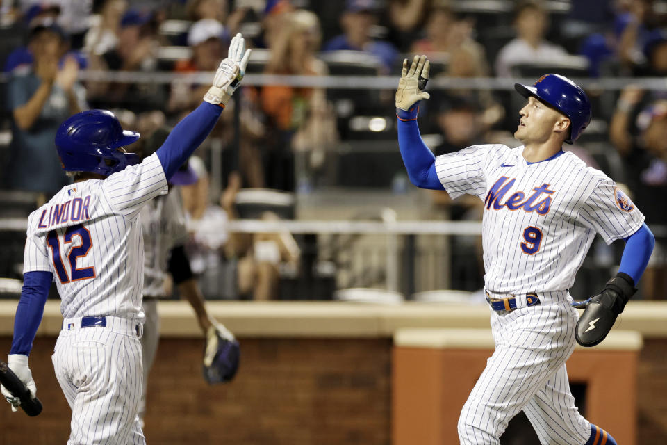 New York Mets' Brandon Nimmo (9) celebrates with Francisco Lindor (12) after scoring a run during the seventh inning of a baseball game on Saturday, Aug. 27, 2022, in New York. (AP Photo/Adam Hunger)